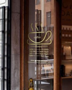 a coffee shop window with a glass sign on it