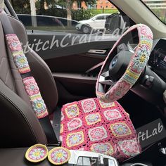 the interior of a car with pink and yellow crocheted seat covers on it