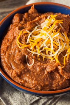 a bowl filled with chili and cheese on top of a table