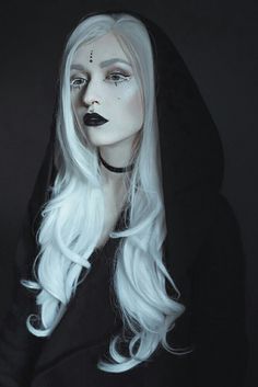 a woman with long white hair and black makeup