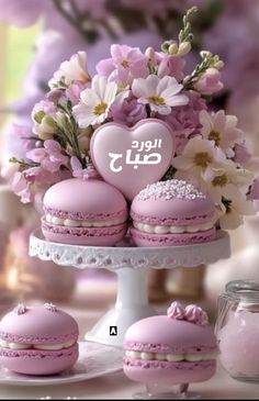 pink macaroons are arranged on a cake stand