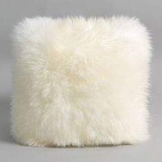 a white furry pillow sitting on top of a table