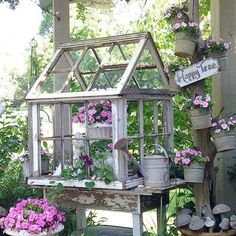 an old birdhouse with flowers and plants in it