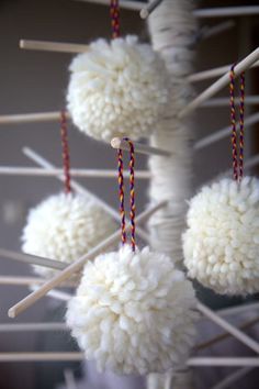 white pom - poms hanging from clothes pins with red and blue string on them