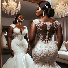 two women in wedding gowns looking at each other's reflection in a mirror