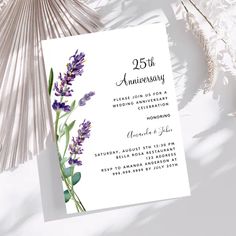 the lavender wedding anniversary party card is shown on top of a table with dried flowers