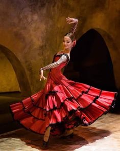 a woman in a red dress is dancing