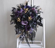 a purple and black bouquet sitting on top of a white chair