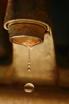 an image of a water drop coming out of a faucet that is leaking