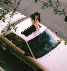 a woman sitting on the hood of a car