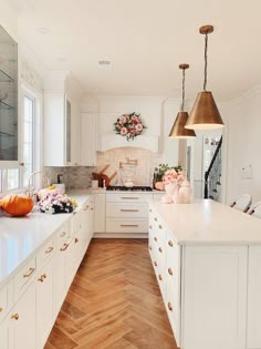 a kitchen filled with lots of white cabinets and counter tops covered in stars hanging from the ceiling