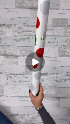 a person holding up a large white tube with red and green polka dots on it