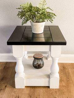 a potted plant sitting on top of a white table next to a wooden floor