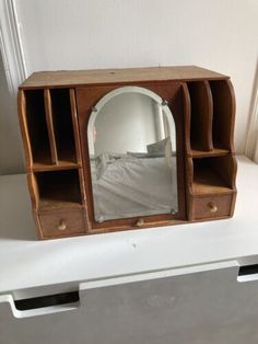 an old wooden dresser with a mirror on it's shelf and drawers underneath the mirror