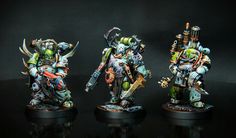 three painted warhammers standing in front of a black background