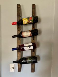 a wine rack made out of wooden pallets with bottles hanging from the top and bottom