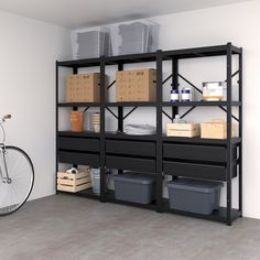 a bike is parked next to a shelf with boxes and containers on it in an empty room