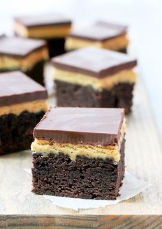 several pieces of cake sitting on top of a wooden cutting board