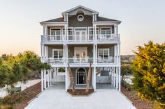 this is an aerial view of a two story house with white balconies and palm trees