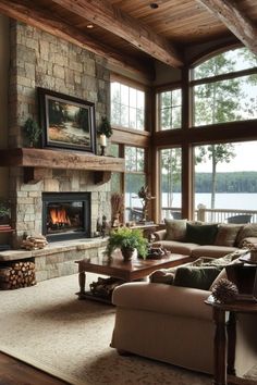 Spacious living room with grand fireplace, exposed beams, and nature-inspired accents in lake house Grand Stone Fireplace, Lake House Colors Interiors, Lake House Dining Room Ideas, Rustic Modern Lake House, Modern Lake House Living Room, Lake House Color Palette, House Bedroom Aesthetic, Lake House Living Room Ideas, Interior Lake House