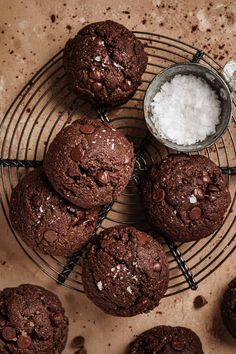 chocolate cookies cooling on a wire rack with sea salt and sugar in the bowl next to them