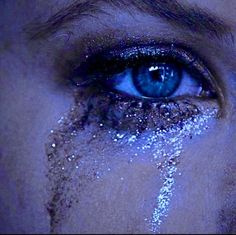 a woman's blue eyes are covered in glitter