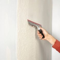 a person using a paint roller on a wall