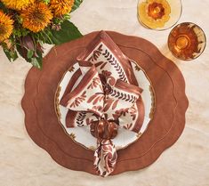 a place setting with plates, napkins and flowers