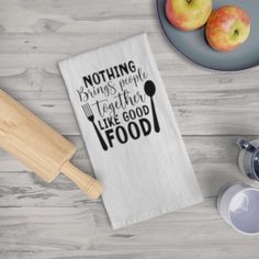 a tea towel with the words nothing brings me together like good food and two apples