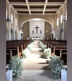 the inside of a church with pews and flowers on either side of the aisle