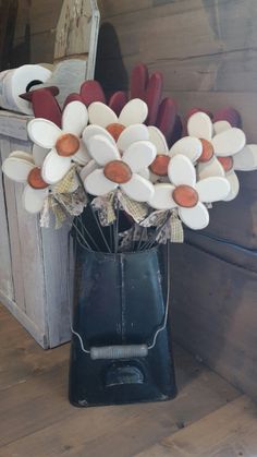 a vase filled with white and red flowers on top of a wooden table next to a mirror