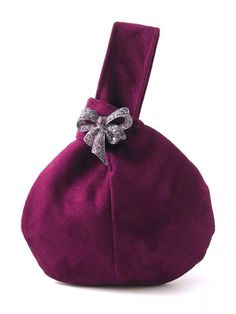 a purple bag with a bow on the front and side, sitting on a white surface