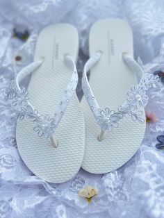 This beautiful white flip flops is wrapped with white satin ribbon, and adorned with white and silver Bridal lace appliqué with sequins, pearls and glass beads hand sewed on it. Ribbon color is white, if you are needing other colors of ribbon or decoration please contact me and will be happy to accommodate you! All flip flops are handmade to order and the production time is 1 to 2 weeks and then please allow additional time for shipping. Amazing for beach, weddings, flower girl or a fancy event, Pearl White Summer Wedding Shoes, Elegant Silver Beach Flip Flops, Elegant Silver Flip Flops For Summer, Elegant White Toe Post Flip Flops, Elegant White Wedding Shoes For Beach Ceremony, White Round Toe Beach Wedding Shoes, Adjustable White Sandals For Beach Wedding, Adjustable Silver Open Toe Flip Flops, Adjustable Silver Flip Flops