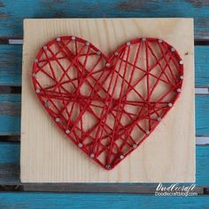 a string art heart on a wooden board