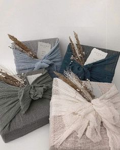 three pillows with bows on them sitting next to each other in front of a white wall