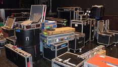 there are many suitcases stacked on top of each other in this room with black walls