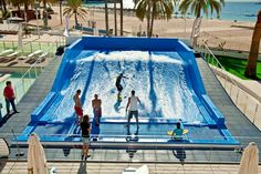 people are standing in front of an artificial wave pool