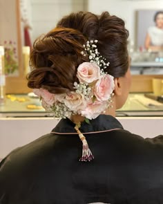 the back of a woman's head with flowers in her hair at a salon