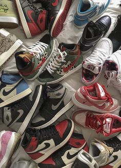 a pile of different colored sneakers on top of each other