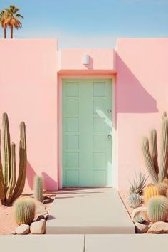 a pink house with cactus plants in front of it and a blue door on the side