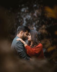 a man and woman embracing each other in front of a waterfall at the end of their engagement session