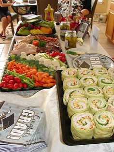 a buffet table filled with rolls and vegetables