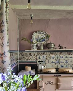 an old fashioned stove in a kitchen with blue and white tiles on the back wall