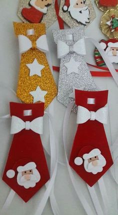 paper santa claus and other holiday decorations on white table cloth with gold sequins