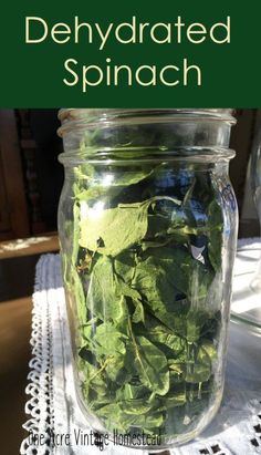 a jar filled with spinach sitting on top of a table