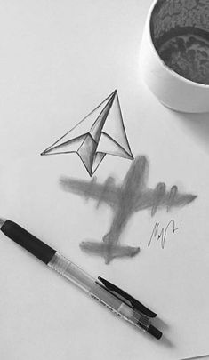 a drawing of a paper airplane next to a cup of coffee