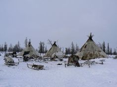 a group of teepee houses sitting on top of snow covered ground