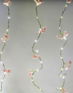 pink flowers with white lights hanging from the ceiling