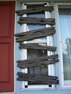 a dog is looking out the window from behind some wood planks that have been placed in front of it