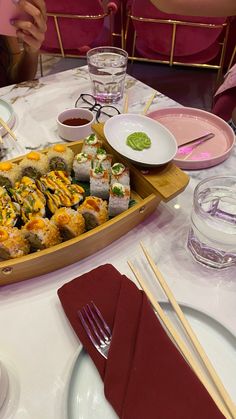 sushi platter with chopsticks and water glasses on the table at a restaurant